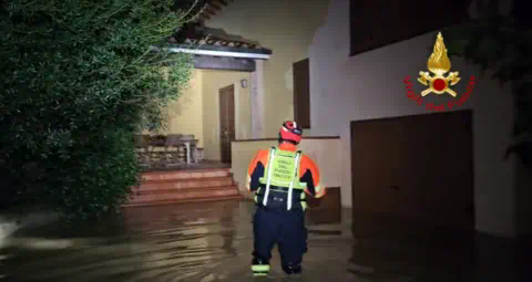 Vigili del Fuoco A firefighter wading into a house amid floodwater